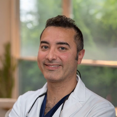 Dentist Abdul-Rahman Addas Smiling In Lab Coat