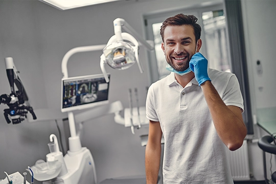 Dentist In Operatory Smiling Over His Mask