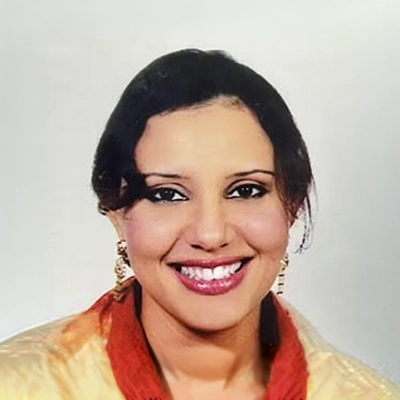 Dentist Sara Mansour Smiling Against White Background